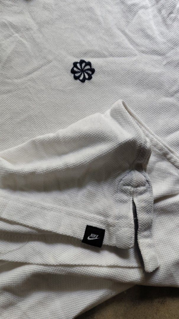 Nike White Polo Shirt XL (Category: Tshirts & Polo Shirts ) located in Quezon City. Submitted by truedeer_cda94c (Listing ID 1470604296, Image 3). Description: - Brand: Nike - Color: White with dark blue contrast tipping - Size: XL - Details: Classic collar, two-button placket, small embroidered flower logo on chest, and small Nike tag at the hem - Measurements (approximate): 20.5 inches chest x 29 inches length.