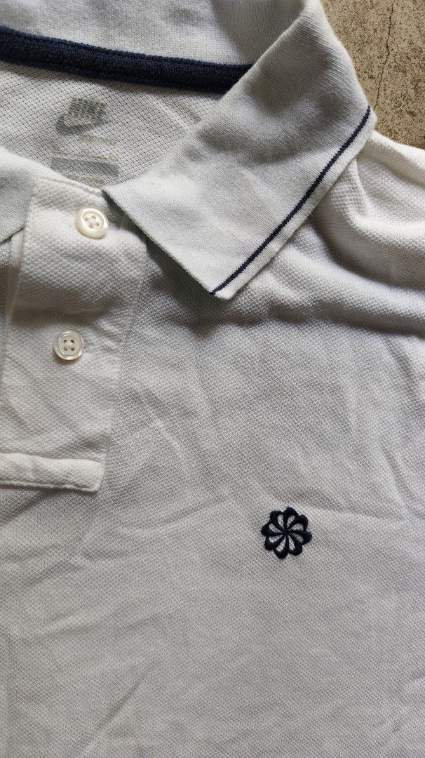 Nike White Polo Shirt XL (Category: Tshirts & Polo Shirts ) located in Quezon City. Submitted by truedeer_cda94c (Listing ID 1470604296, Image 2). Description: - Brand: Nike - Color: White with dark blue contrast tipping - Size: XL - Details: Classic collar, two-button placket, small embroidered flower logo on chest, and small Nike tag at the hem - Measurements (approximate): 20.5 inches chest x 29 inches length.