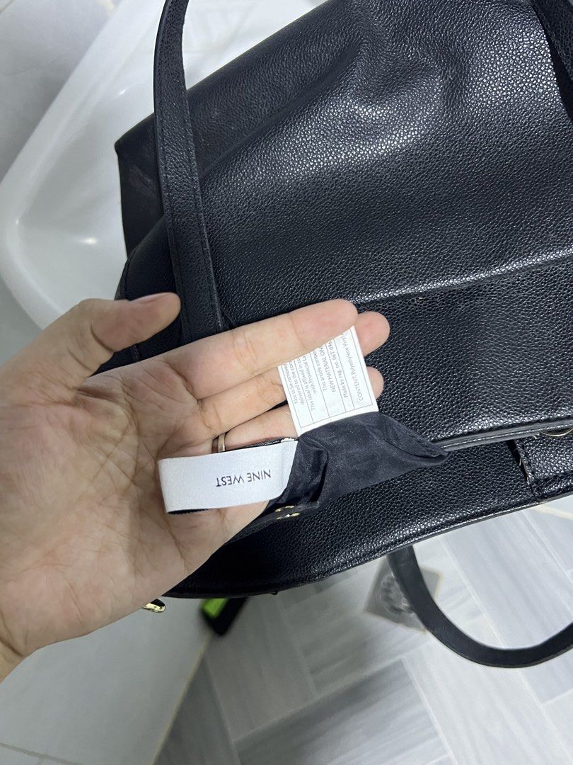 Nine West black tote bag (Category: Tote Bags) located in Manila. Submitted by jj0451315 (Listing ID 1470614094, Image 2). Description: - Brand: Nine West - Material: 100% Polyvinyl Chloride (faux leather) with fabric lining - Color: Classic black with elegant gold lettering - Straps: Double shoulder straps with sturdy metal hardware - Closure: Secure top magnetic snap closure - Interior: Includes a handy zipper pocket for organization.