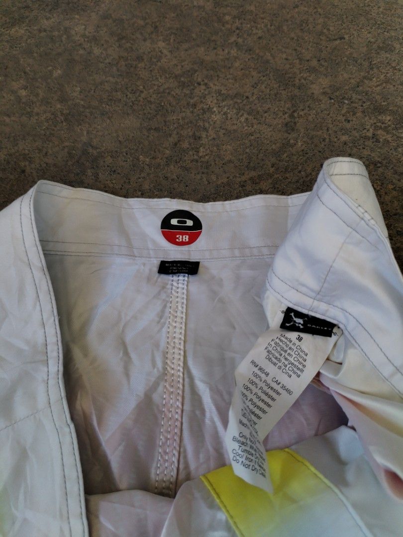 Oakley Gradient Surf Boardshorts Size 38 (Category: Swim Trunks & Board Shorts) located in Legazpi City. Submitted by justinbarcelon (Listing ID 1470683874, Image 2). Description: - Brand: Oakley - Size: 38 - Design: Gradient fading from yellow and red to black and white with bold left-leg branding - Material: 100% polyester - Features: Secure drawstring waist closure and a convenient side cargo pocket with the iconic Oakley ellipse logo - Ideal 