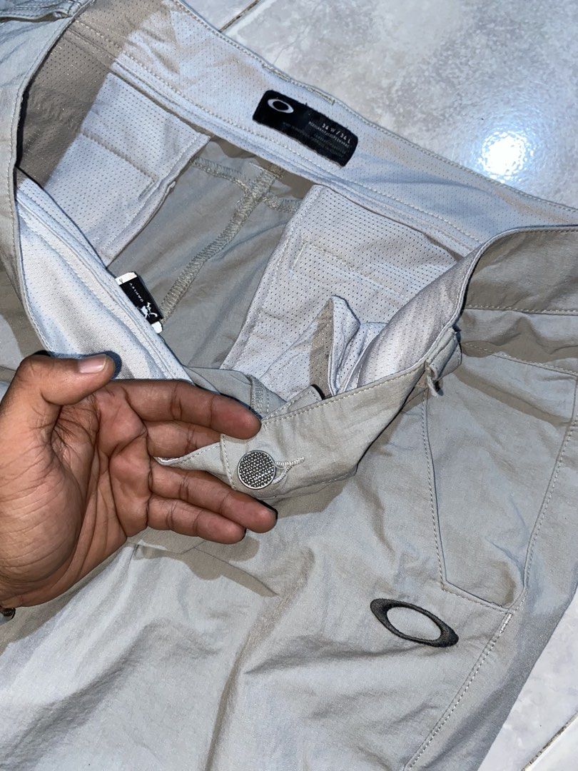 OAKLEY MENS GOLF PANTS (Category: Trousers) located in Dumaguete. Submitted by gearhuntph (Listing ID 1470603980, Image 3). Description: OAKLEY Embroidered Logo Design Technical Performance / Golf Pants PRICE: 2500❗️ Brand: Oakley • Color: Light / Stone Grey • Size Tag: 34 • Fit: Regular Fit • Logo: Raised Oakley Ellipse logo on left thigh • Details: Vented side ankle hems, mesh-lined interior waistband & pocketing, branded hardware button. Actua