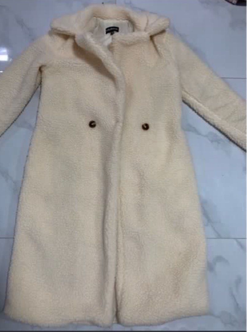 Off White Teddy Bear Coat (Category: Coats, Jackets and Outerwear) located in Manila. Submitted by decluterthings888 (Listing ID 1470560087, Image 2). Description: - Color: Off-white - Material: Super soft fleece with full lining - Style: Double-breasted with brown tortoiseshell buttons - Design: Wide lapel collar and long sleeves - Ideal for: Cozy and warm winter outerwear.