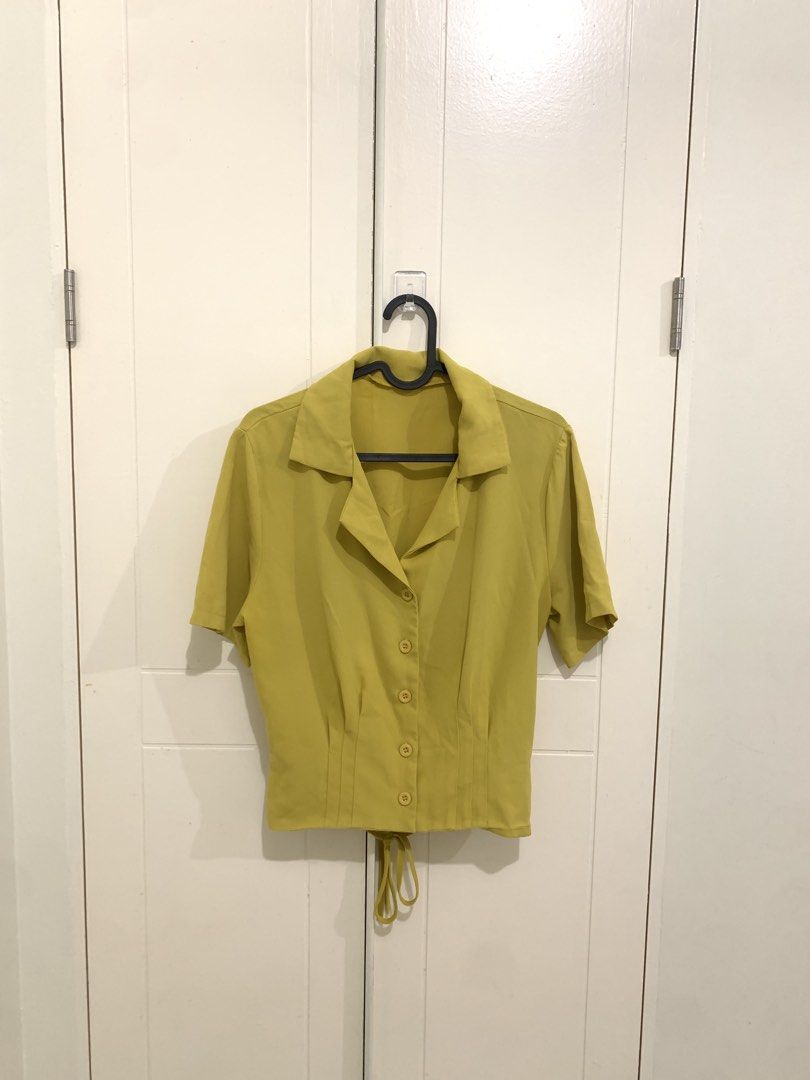 Olive Green Short Sleeve Button Down Blouse with Back Tie (Category: Blouses) located in Pasig City. Submitted by lovedbyri (Listing ID 1470688519, Image 1). Description: - Color: Olive green - Design: Short sleeves, lapel collar, and front button closure with matching buttons - Fit: Fitted waist with flattering panel stitching - Detail: Adjustable tie at the back hem - Material: Lightweight and breathable fabric - Styling: Perfect for casual dai