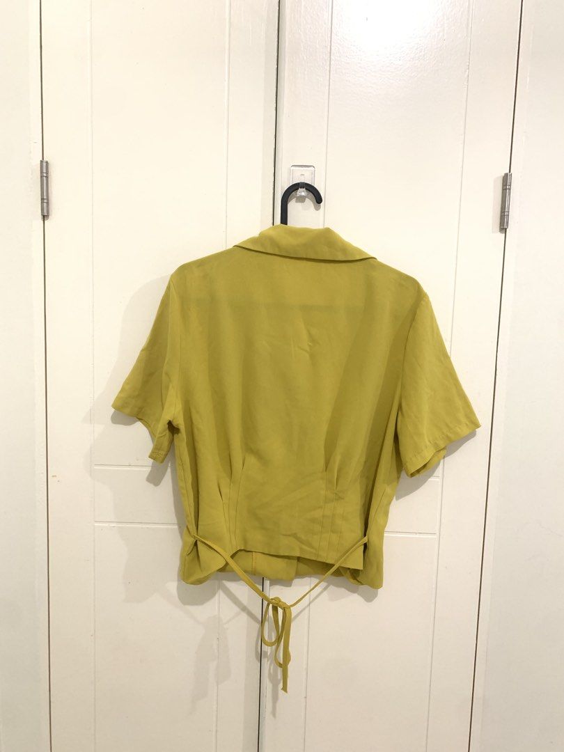 Olive Green Short Sleeve Button Down Blouse with Back Tie (Category: Blouses) located in Pasig City. Submitted by lovedbyri (Listing ID 1470688519, Image 2). Description: - Color: Olive green - Design: Short sleeves, lapel collar, and front button closure with matching buttons - Fit: Fitted waist with flattering panel stitching - Detail: Adjustable tie at the back hem - Material: Lightweight and breathable fabric - Styling: Perfect for casual dai
