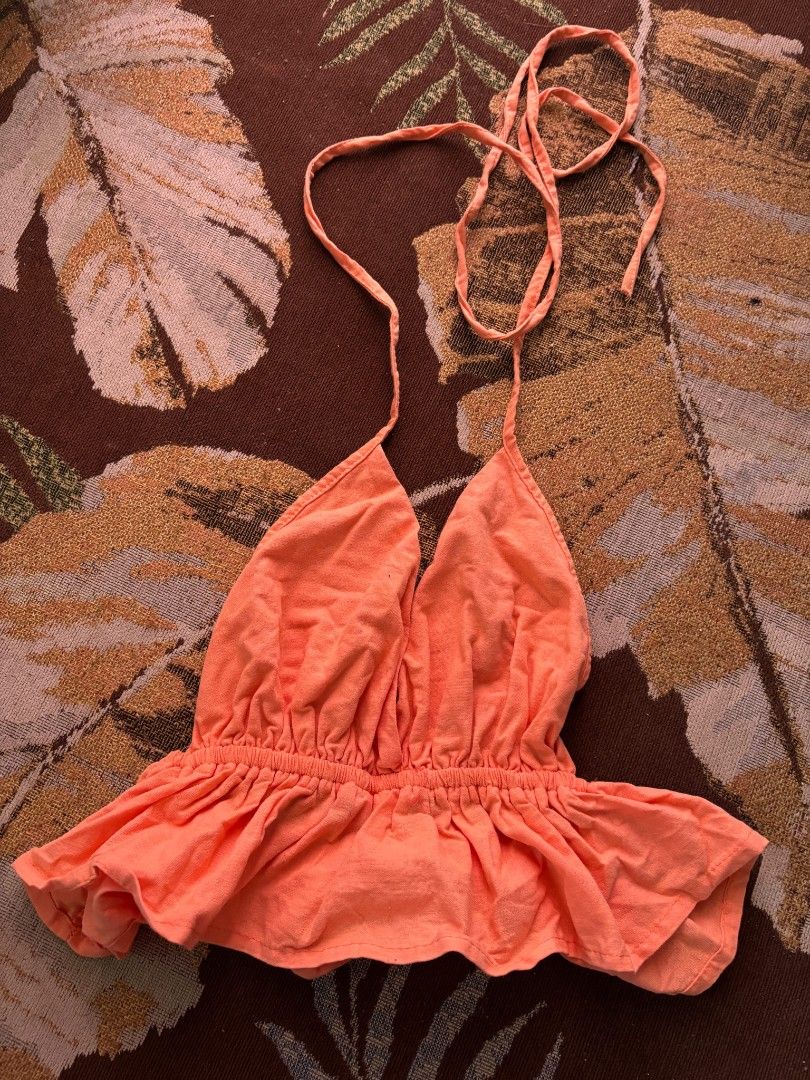 Orange Halter Neck Peplum Crop Top (Category: Sleeveless) located in Quezon City. Submitted by giveitalife (Listing ID 1470716017, Image 1). Description: - Color: Bright orange - Style: Halter crop top with deep V-neck and adjustable ties - Fit: Stretchy smocked waist and ruffled peplum hem - Material: Lightweight and breathable fabric, perfect for warm weather - Occasion: Ideal for festivals, beach trips, or casual days out - Pairing: Looks grea