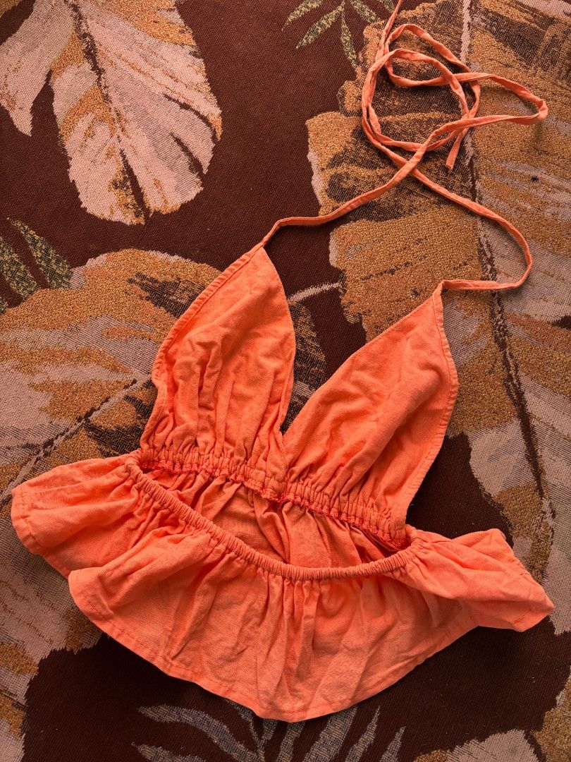 Orange Halter Neck Peplum Crop Top (Category: Sleeveless) located in Quezon City. Submitted by giveitalife (Listing ID 1470716017, Image 2). Description: - Color: Bright orange - Style: Halter crop top with deep V-neck and adjustable ties - Fit: Stretchy smocked waist and ruffled peplum hem - Material: Lightweight and breathable fabric, perfect for warm weather - Occasion: Ideal for festivals, beach trips, or casual days out - Pairing: Looks grea