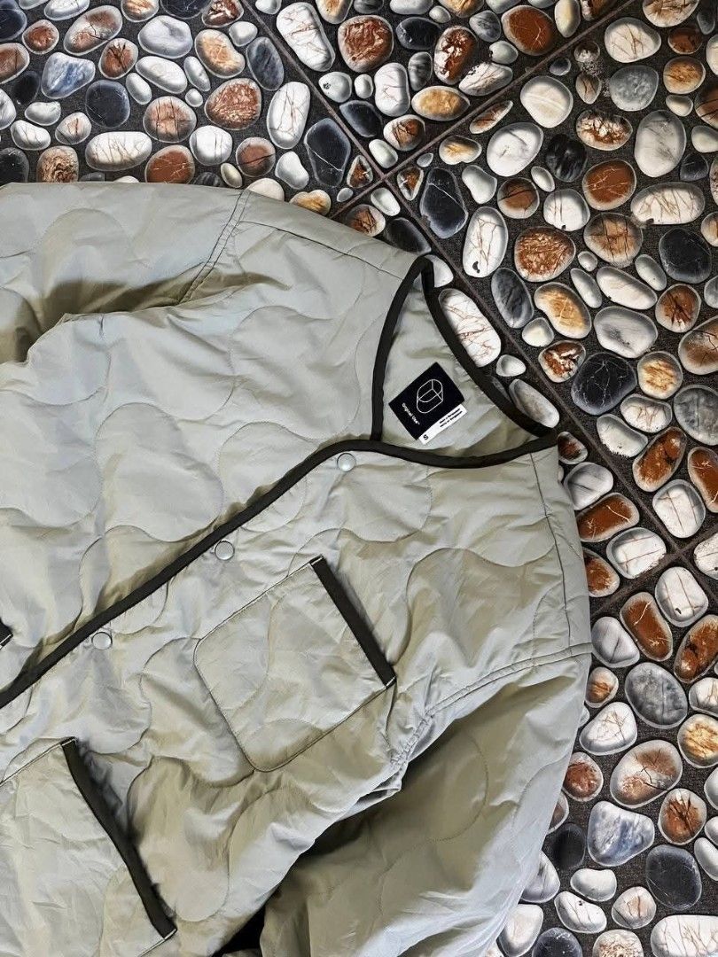Original Use Quilted Snap-Up Jacket Sage Green Size S (Category: Coats, Jackets and Outerwear) located in Baler. Submitted by vansonearth (Listing ID 1470699726, Image 3). Description: - Brand: Original Use - Color: Sage Green - Size: Small - Material: 100% recycled polyester (shell, filling, and lining) - Closure: Snap-button front with contrast dark piping - Pockets: One chest pocket and two waist patch pockets - Condition: Lightweight layering