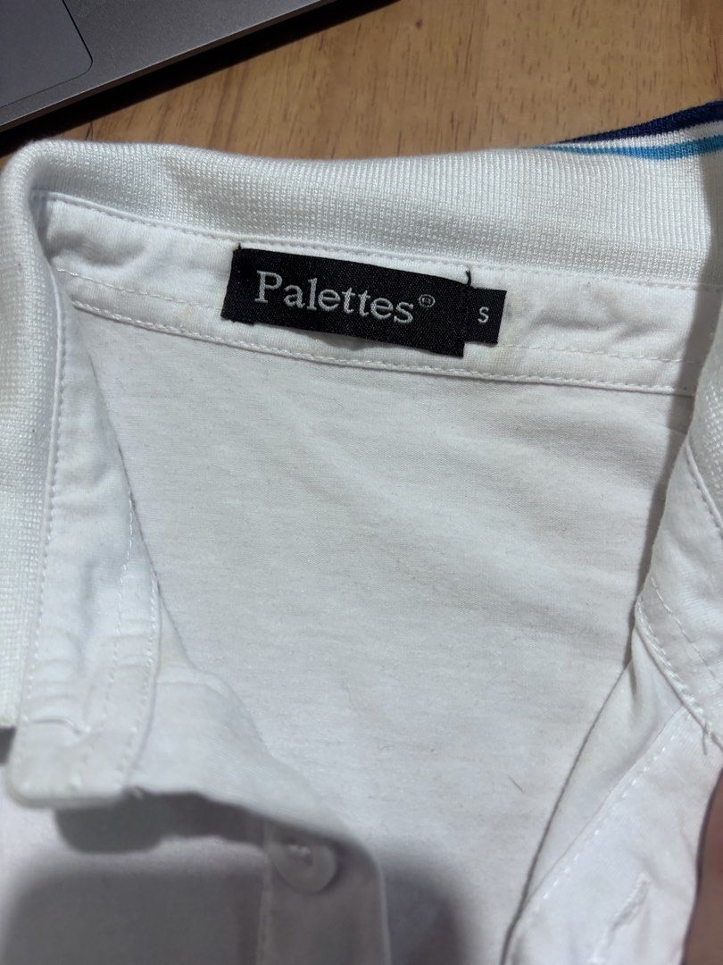 Palettes White Polo Shirt Size S (Category: Tshirts & Polo Shirts ) located in Manila. Submitted by ninja2130 (Listing ID 1470588245, Image 2). Description: - Brand: Palettes - Color: White with blue and navy stripe details on the collar - Size: Small - Material: Lightweight cotton for all-day comfort - Features: Short sleeves, standard collar, and a 3-button placket - Condition: Pre-owned with normal signs of washing and wear.