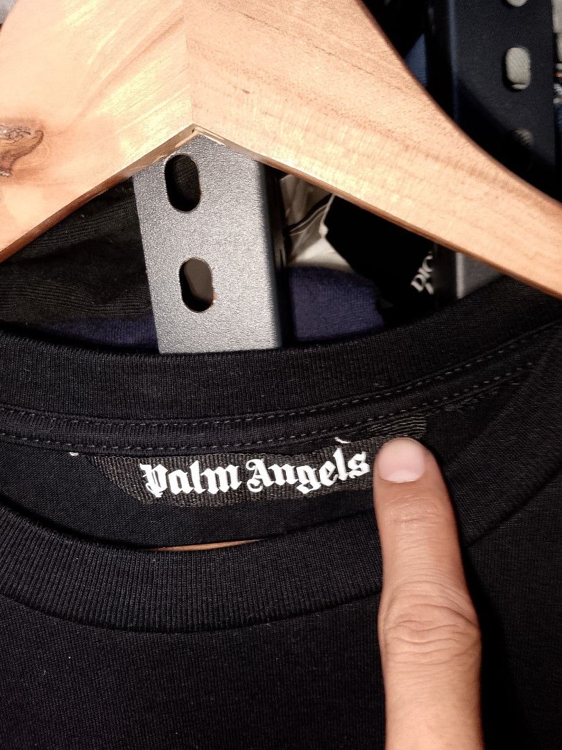 Palm Angels Black Tee Size M (Category: Tshirts & Polo Shirts ) located in Manila. Submitted by mjthrifted_second (Listing ID 1470616977, Image 3). Description: - Brand: Palm Angels - Color: Black with white gothic logo (chest and back) - Size: Medium (Regular Fit) -Dimes: 21/29 - Material: 100% Cotton, Made in Italy - Condition: Brand new with tags and care label - Style: Classic crew neck, short sleeves - 100% Authentic & high quality.