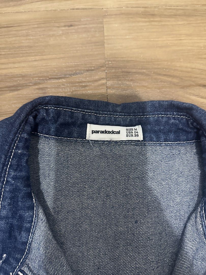 Paradoxical Denim Short Sleeve Button Up Shirt (Category: Shirts) located in Paranaque City. Submitted by declutterwyae (Listing ID 1470645823, Image 3). Description: - Brand: Paradoxical - Color: Dark blue wash with white contrast stitching - Style: Short sleeve denim shirt, collared neck, front button closure - Features: Two functional chest pockets - Size: Medium (USA 04, EUR 38) - Condition: Clean, well-maintained.
