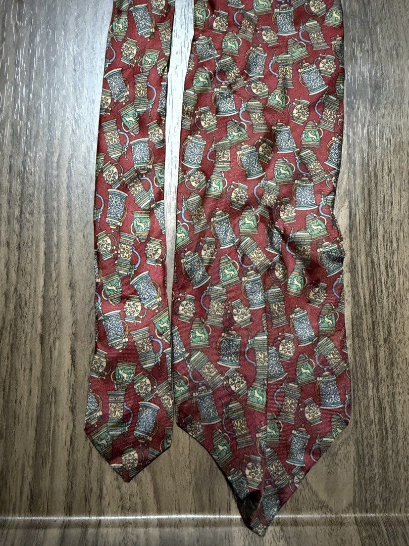 Pierre Balmain Paris Silk Necktie Beer Stein Print (Category: Ties) located in Digos. Submitted by old_soul. (Listing ID 1470694967, Image 1). Description: - Brand: Pierre Balmain Paris (Made in France) - Material: Premium silk with a smooth finish - Color & Design: Rich red with an all-over traditional beer steins and mugs print - Size: Standard width - Style: Great for adding character to formal wear or business casual outfits.
