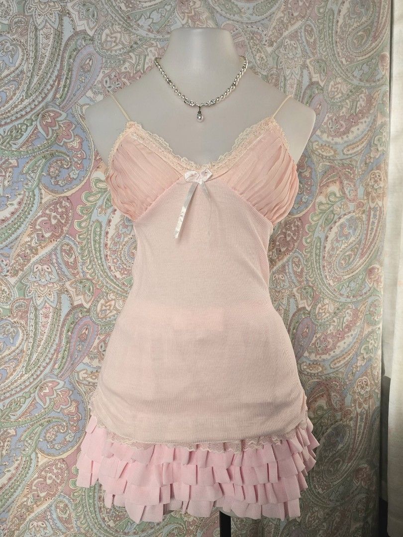Pink camisole with lace trim (Category: Sleeveless) located in Dagupan City. Submitted by chislocker14 (Listing ID 1470598043, Image 1). Description: - Color: Soft pink - Material: Stretchy ribbed knit fabric - Design: Spaghetti straps, pleated bust with lace trim and white ribbon bow - Feature: Attached layered pink ruffled skirt at the hem - Style: Coquette / Y2K / Casual cute.