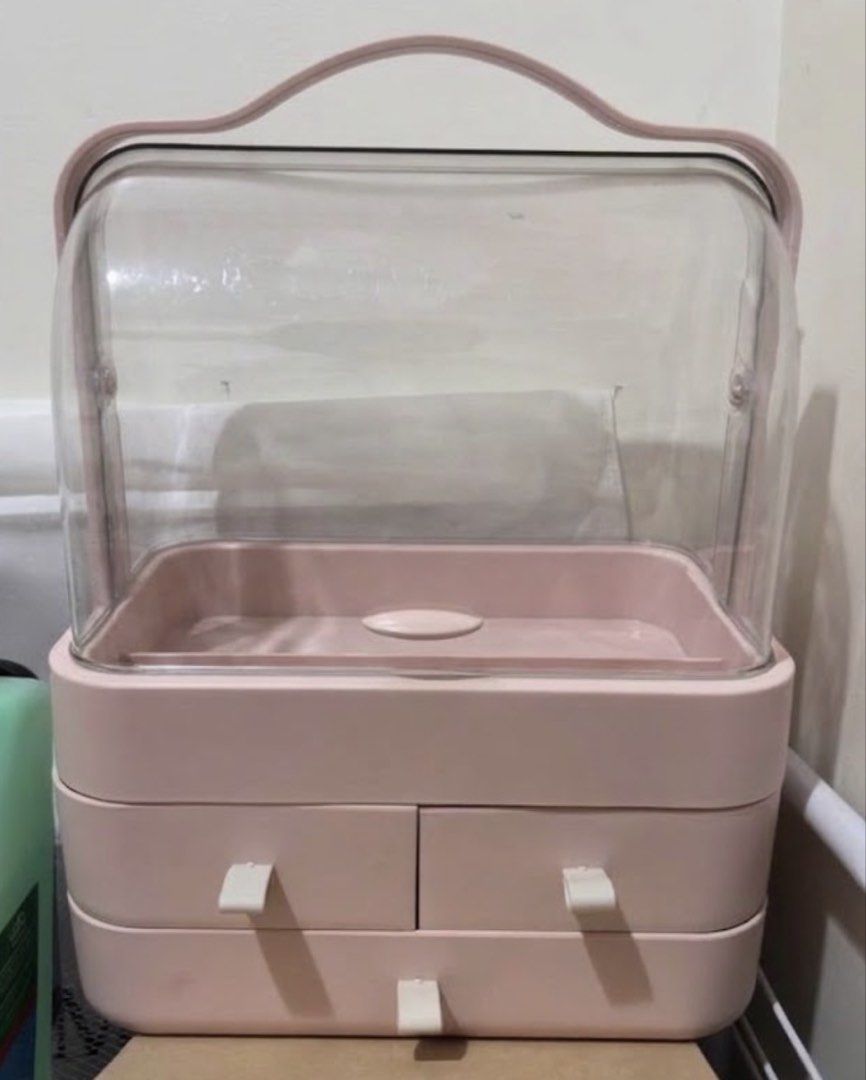 Pink Makeup Organizer Box with Clear Dustproof Cover (Category: Accessory Holder, Box & Organizers) located in Quezon City. Submitted by injooool (Listing ID 1470728626, Image 1). Description: - Color: Dusty Pink - Design: Dustproof with a clear dome top for easy viewing - Portability: Built-in top handle for convenient carrying - Storage: Two small middle drawers and one large bottom drawer - Capacity: Spacious enough for lipsticks, brushes, and