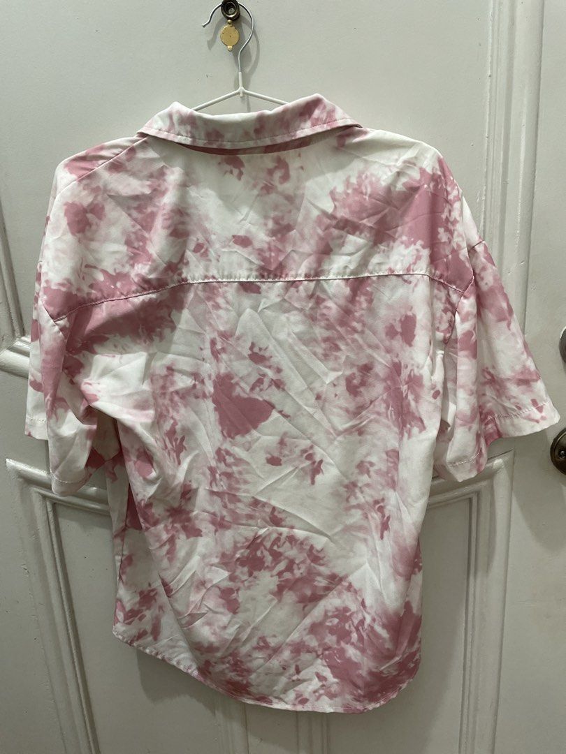Pink Tie-Dye Short Sleeve Button-Up Shirt (Category: Tshirts & Polo Shirts ) located in Cainta. Submitted by nancygoreng (Listing ID 1470620997, Image 2). Description: - Brand: ZHUQINGCHUN - Color: Pink and white tie-dye - Style: Short sleeve button-up with collared neckline - Fit: Lightweight and loose fit - Condition/Use: Great casual piece for everyday wear.