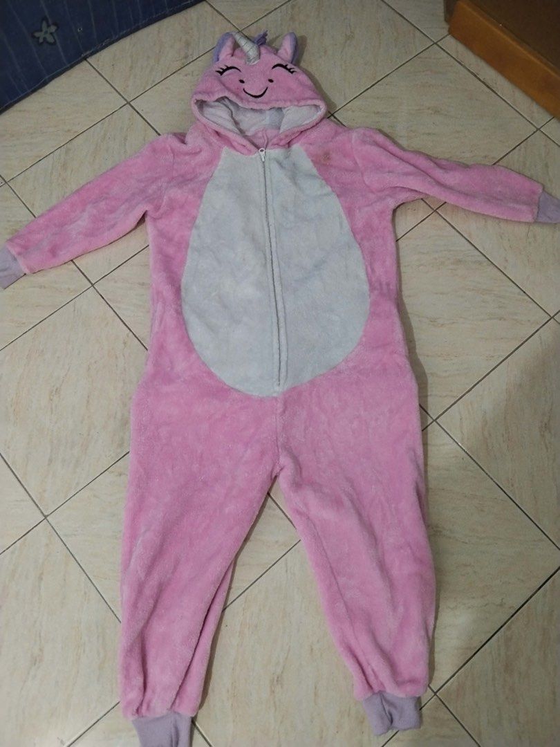 Pink Unicorn Onesie Pyjamas Costume (Category: Coats, Jackets and Outerwear) located in Calamba. Submitted by rhiajapansurplus-babystuff-03 (Listing ID 1470619352, Image 1). Description: - Fluffy pink and white unicorn onesie - Super soft, warm plush material ideal for lounging or costumes - Features a hood with cute ears, horn, and mane, plus a purple tail and cuffs - Convenient zip-up front closure - Flaw: Small stain on the left chest area nea