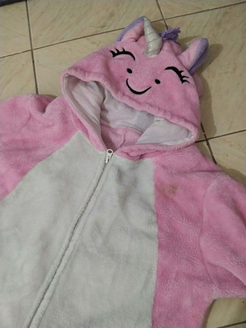 Pink Unicorn Onesie Pyjamas Costume (Category: Coats, Jackets and Outerwear) located in Calamba. Submitted by rhiajapansurplus-babystuff-03 (Listing ID 1470619352, Image 2). Description: - Fluffy pink and white unicorn onesie - Super soft, warm plush material ideal for lounging or costumes - Features a hood with cute ears, horn, and mane, plus a purple tail and cuffs - Convenient zip-up front closure - Flaw: Small stain on the left chest area nea
