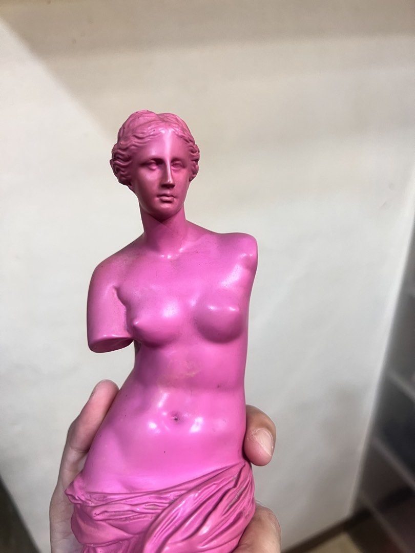 Pink Venus de Milo Sculpture Statue Art Decor (Category: Figurines & Statues) located in Caloocan City. Submitted by ericavi_g (Listing ID 1470579251, Image 2). Description: - Style: Vibrant modern pop art twist on the classic Venus de Milo - Color: Bright pink statue with a dual-tone pink and orange base - Material: Heavy, sturdy resin or plaster - Condition: Excellent, clean surface with no chips or cracks - Display: Stands firmly on its wooden