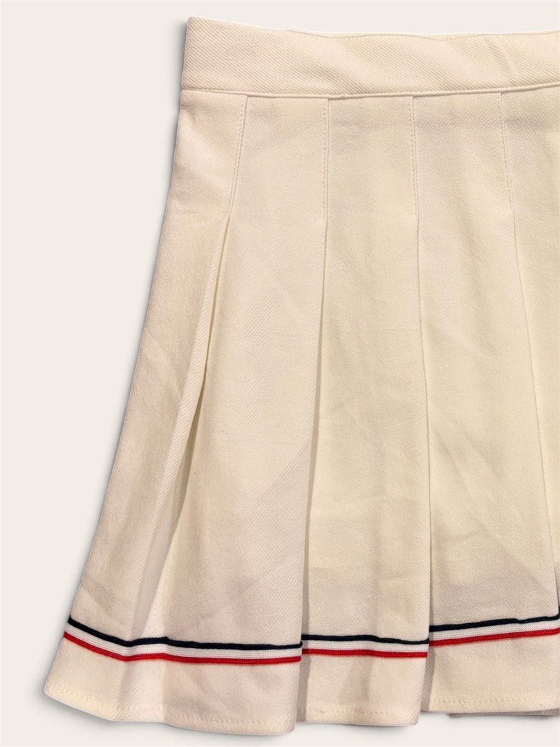 pleated tennis skirt (Category: Skirts) located in Muntinlupa City. Submitted by leileip (Listing ID 1470574069, Image 2). Description: - Style: High-waisted pleated tennis skirt - Design: Red and navy blue striped trim on the bottom hem - Material: Structured fabric that holds its shape well - Versatility: Ideal for casual wear or sporty outfits - Pairing: Looks great with simple tops and sneakers.