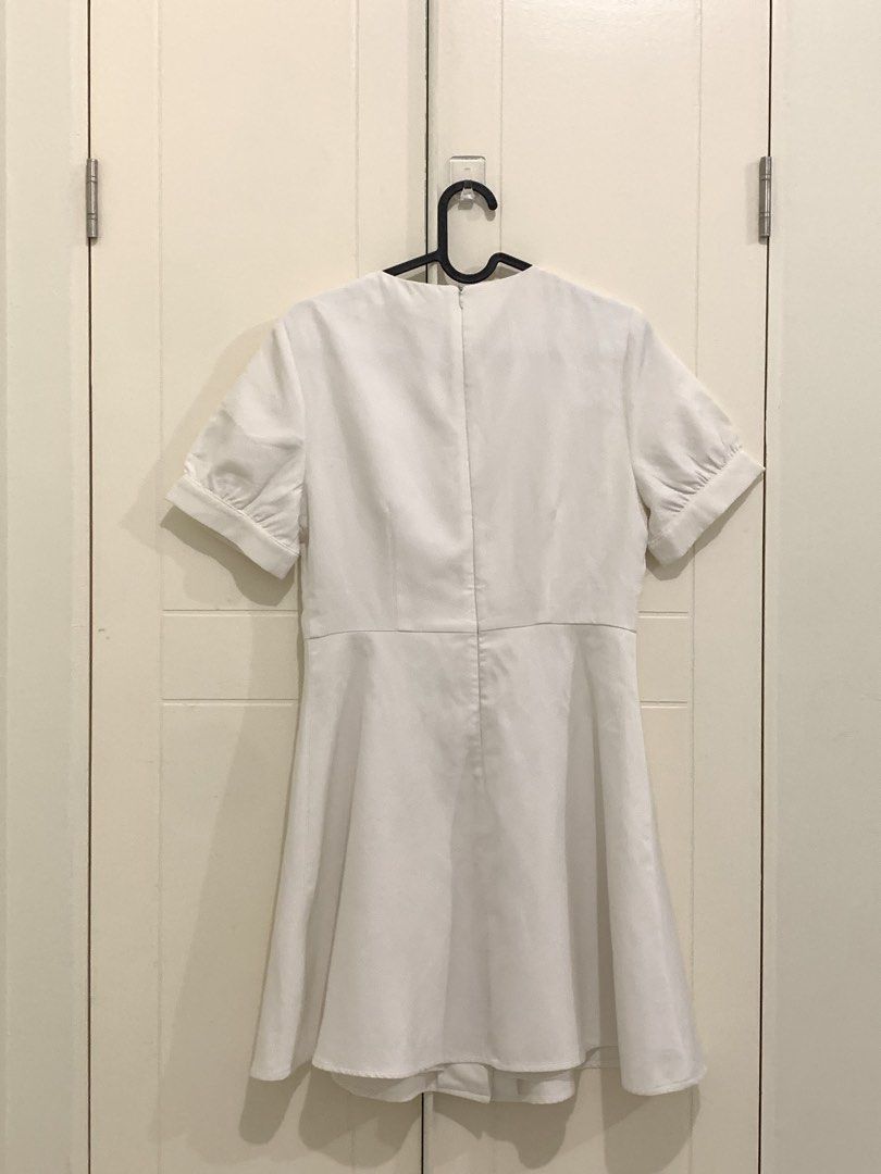 Pomelo Collection White Dress Size M (Category: Dresses) located in Pasig City. Submitted by lovedbyri (Listing ID 1470631611, Image 2). Description: - Brand: Pomelo Collection - Size: M (Tag attached) - Color: Solid White - Style: Mini dress with flared A-line skirt silhouette - Details: Short puffed sleeves with cuffed hems, V-neckline, decorative metal-trimmed front buttons - Closure: Back zip closure .
