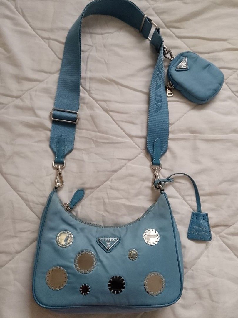 Prada Blue Mirror Re-Edition Bag (Category: Luxury Bags & Wallets) located in Manila. Submitted by anvicnicajeff (Listing ID 1470669817, Image 1). Description: - Authentic Prada blue nylon shoulder bag -100% AUTHENTIC you can grab my photo and legit check it to the group -Meetup only in shangrila shaw so that you can see it clearly - Eye-catching round mirror patches on the front -Lost chain but still has the sling strap - Includes a matching adj