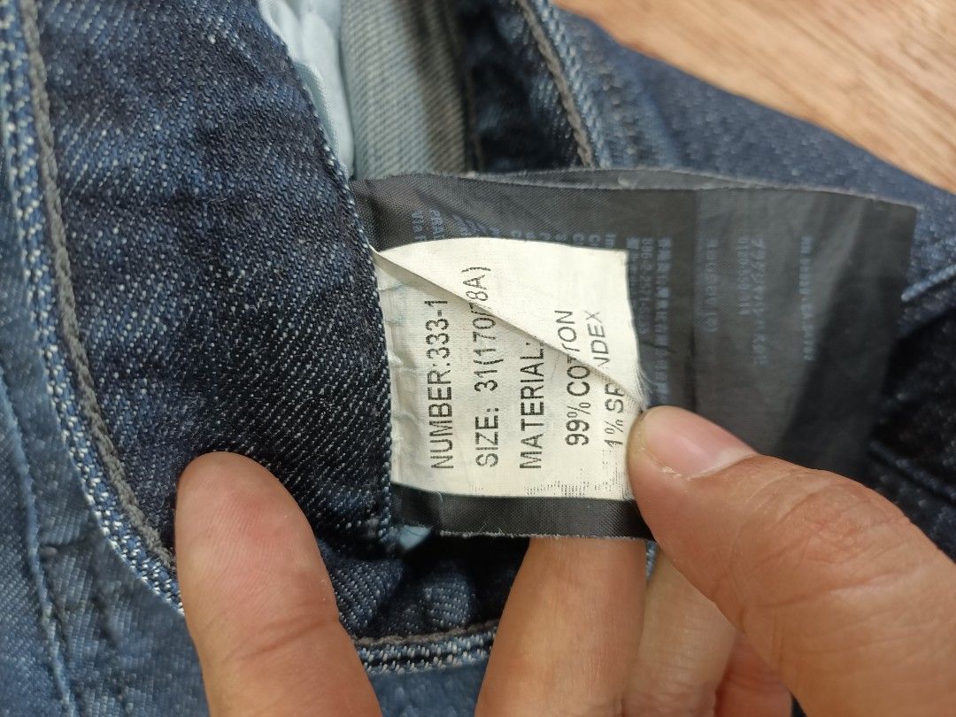 Prada Dark Blue Denim Jeans Size 31 (Category: Jeans) located in Bayombong. Submitted by rheaaa00530 (Listing ID 1470670317, Image 3). Description: - Brand: Prada - Color: Dark blue with distressed wash - Size: Tagged 31 - Material: 99% cotton, 1% spandex for a comfortable fit - Fit: Standard straight fit - Details: Branded button closure, custom pocket rivets, and signature Prada triangle logo badge on the back pocket - Condition: Clean inside a