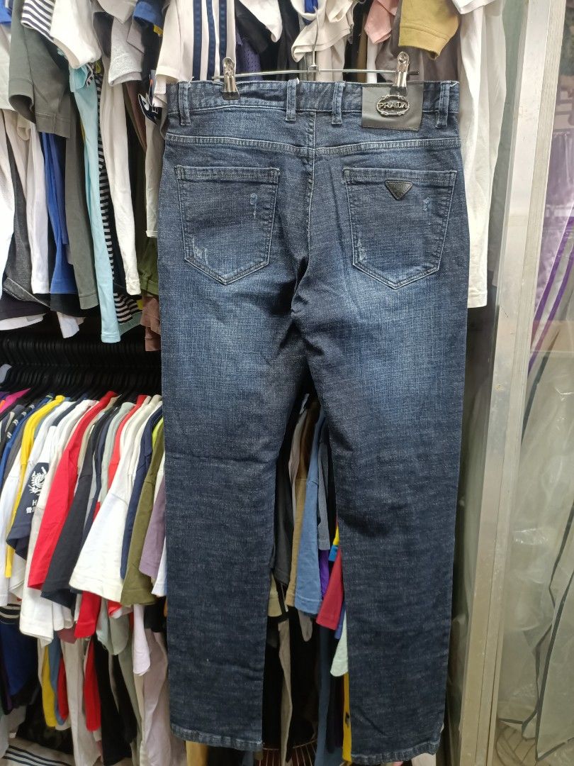 Prada Dark Blue Denim Jeans Size 31 (Category: Jeans) located in Bayombong. Submitted by rheaaa00530 (Listing ID 1470670317, Image 2). Description: - Brand: Prada - Color: Dark blue with distressed wash - Size: Tagged 31 - Material: 99% cotton, 1% spandex for a comfortable fit - Fit: Standard straight fit - Details: Branded button closure, custom pocket rivets, and signature Prada triangle logo badge on the back pocket - Condition: Clean inside a