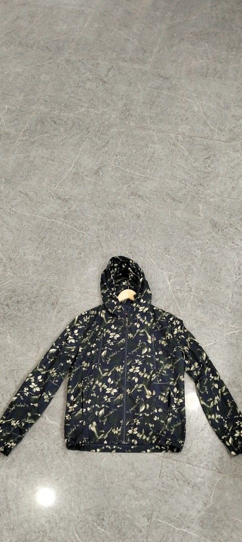 Prada Milano Floral Print Hooded Jacket (Category: Coats, Jackets and Outerwear) located in Bacolod City. Submitted by hurleydediamante0513 (Listing ID 1470589245, Image 2). Description: - Brand: Prada Milano - Style: Lightweight hooded windbreaker / layering jacket - Color: Dark blue with all-over floral and leaf pattern - Hardware: Premium Riri zippers with branded metal pulls - Features: Drawstring hood and functional chest utility pockets - C
