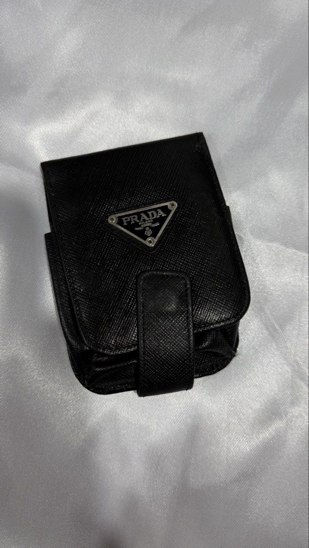 Prada Saffiano Leather Makeup Case Mirror Pouch (Category: Luxury Bags & Wallets) located in Baguio. Submitted by zeemoda01 (Listing ID 1470591965, Image 1). Description: - Authentic Prada lipstick or essentials case - Crafted from durable black Saffiano leather - Iconic enamel triangle logo plaque on the front - Secure flap closure with snap button - Built-in interior mirror with Prada Milano gold stamp - Made in Italy - Compact, structured desi