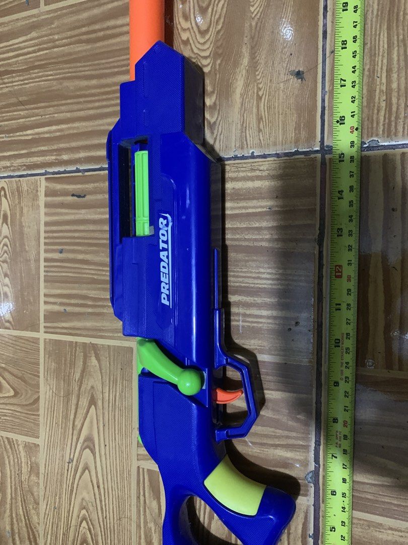 Predator Toy Blaster Blue Orange Green (Category: Action & Battle Toys) located in Antipolo. Submitted by cebb888 (Listing ID 1470639606, Image 2). Description: - Product: Predator toy blaster - Size: Measures approximately 25 inches long - Colorway: Blue main body with bright orange barrel extension and green accents, bolt handle, and grip panels - Features: Orange trigger inside safety guard - Perfect for: Backyard games and target practice - w