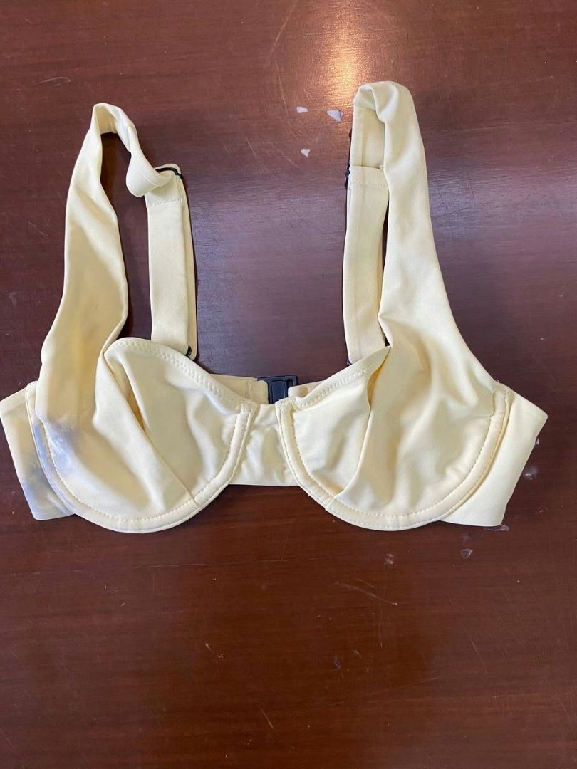 *Preloved Blackbough Bikini Top Yellow S (Category: Bikinis & Swimsuits) located in Muntinlupa City. Submitted by irene.aragon.navarro (Listing ID 1470627966, Image 1). Description: Pale yellow underwire bikini top. Structured cups with supportive wire underneath. Wide shoulder straps with adjustable metal-ring sliders. Back clasp closure made of dark plastic. Soft stretch swimwear fabric. Note the slight blue stain on the lower left cup area. Cl