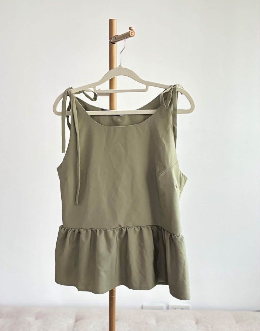 Preloved SM woman Plus Tie Blouse (Category: Sleeveless) located in Pasig City. Submitted by catsyybooo (Listing ID 1470599055, Image 1). Description: - Color: Sage Green - Style: Sleeveless top with scoop neckline and cute peplum ruffle hem - Details: Adjustable tie straps on the shoulders - Fabric: Smooth and lightweight, ideal for warm weather - Versatility: Easy to pair with shorts, skirts, or jeans.