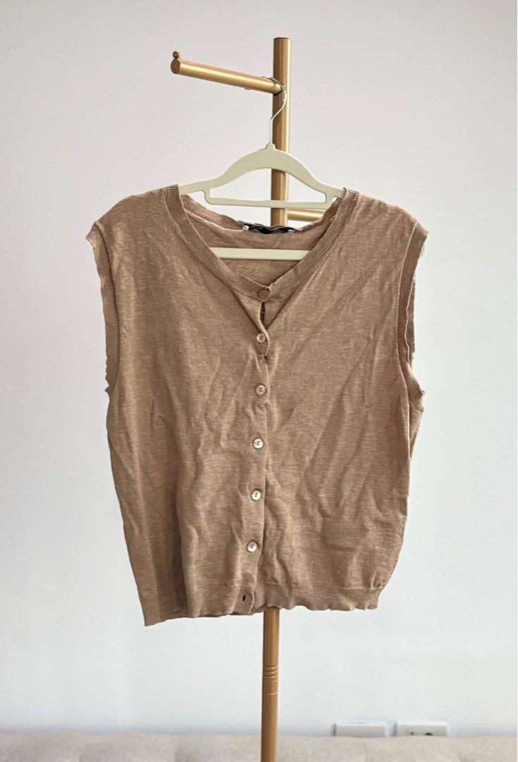 Preloved Zara Brown Top Knitted (Category: Sleeveless) located in Pasig City. Submitted by catsyybooo (Listing ID 1470599938, Image 1). Description: - Color: Classic Beige - Design: V-neckline with functional white button-down front - Details: Ribbed hem and arm openings for a snug fit - Material: Lightweight, breathable knit sweater fabric - Styling: Sleeveless, great for layering over shirts or wearing on its own - Condition: Brand new / Excell