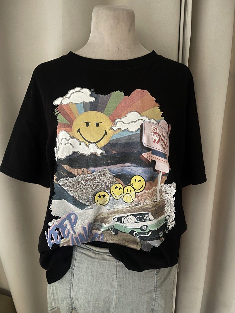 premium Joy by Lily Smiley World (Category: Shirts) located in Cainta. Submitted by zlove111 (Listing ID 1470738271, Image 2). Description: - Brand: Joy by Lily - Color: Classic Black - Design: Front collage graphic with smiley faces, rainbow, car, and 'Keep Moving Forward' text -up to xl - Condition: Excellent, ready to wear - Perfect for casual, everyday streetwear.