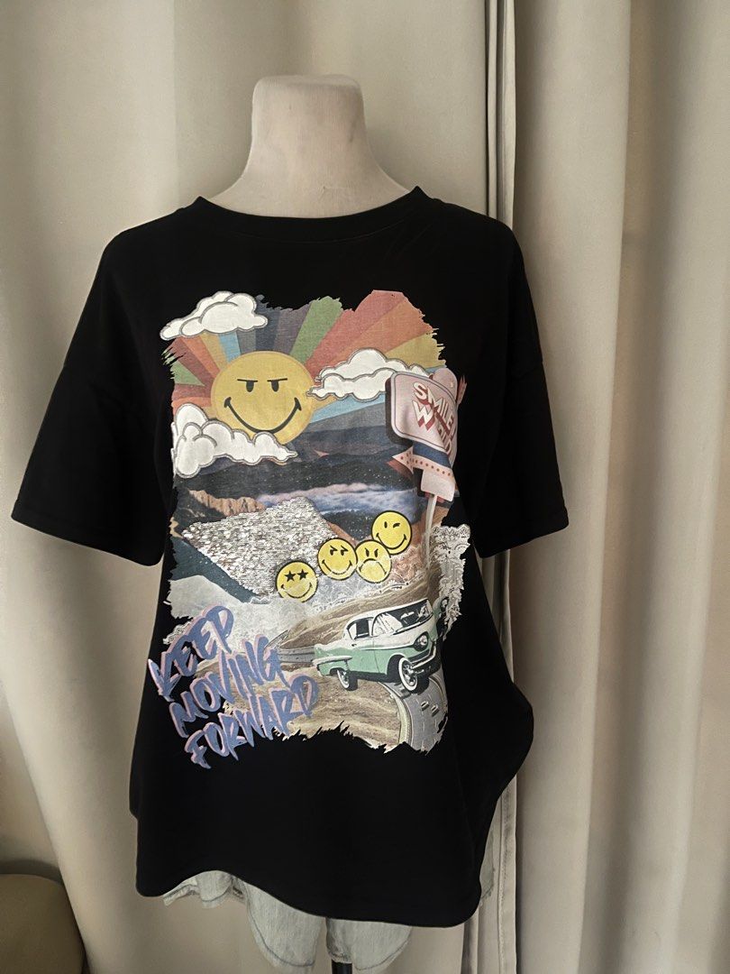 premium Joy by Lily Smiley World (Category: Shirts) located in Cainta. Submitted by zlove111 (Listing ID 1470738271, Image 1). Description: - Brand: Joy by Lily - Color: Classic Black - Design: Front collage graphic with smiley faces, rainbow, car, and 'Keep Moving Forward' text -up to xl - Condition: Excellent, ready to wear - Perfect for casual, everyday streetwear.