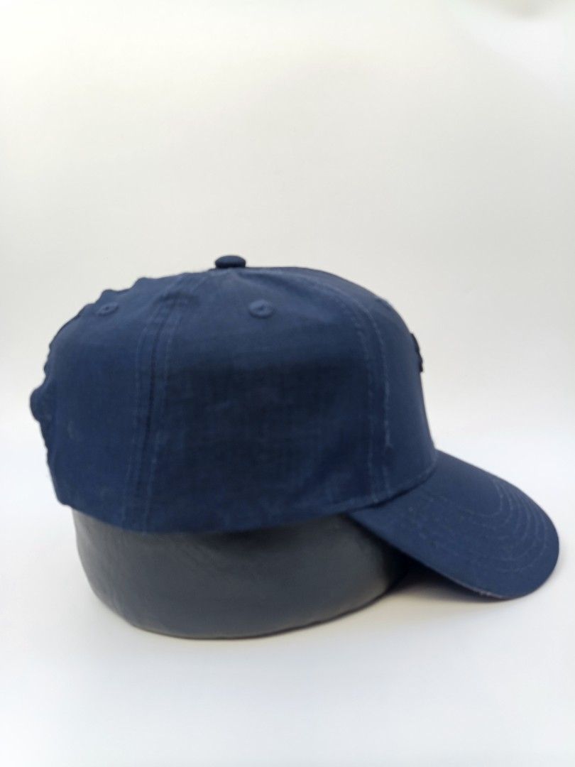 Puma Navy Blue Embroidered Logo Baseball Cap OSFA (Category: Caps & Hats) located in Imus. Submitted by grindhouse.thriftshop (Listing ID 1470606889, Image 2). Description: - Brand: Puma - Color: Navy blue - Design: Embroidered leaping cat logo on the front - Fit: One size fits all with an adjustable back strap - Material: 100% polyester body, 100% cotton sunshade back - Details: Branded interior taping along the seams - Condition: Clean inside a