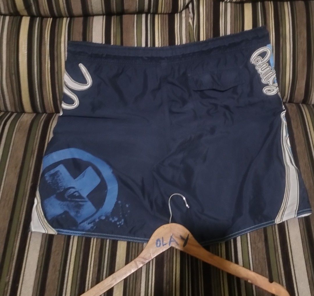 Quiksilver Blue Board Shorts Swim Trunks (Category: Swim Trunks & Board Shorts) located in Taguig. Submitted by conniemdcruz (Listing ID 1470699219, Image 2). Description: - Authentic Quiksilver board shorts - Stylish light blue and dark blue colorway with block panel design - Large brand logo text printed vertically on the side - Adjustable white drawstring waist with matching eyelets - Convenient back pocket with flap closure - Ideal for swimmi