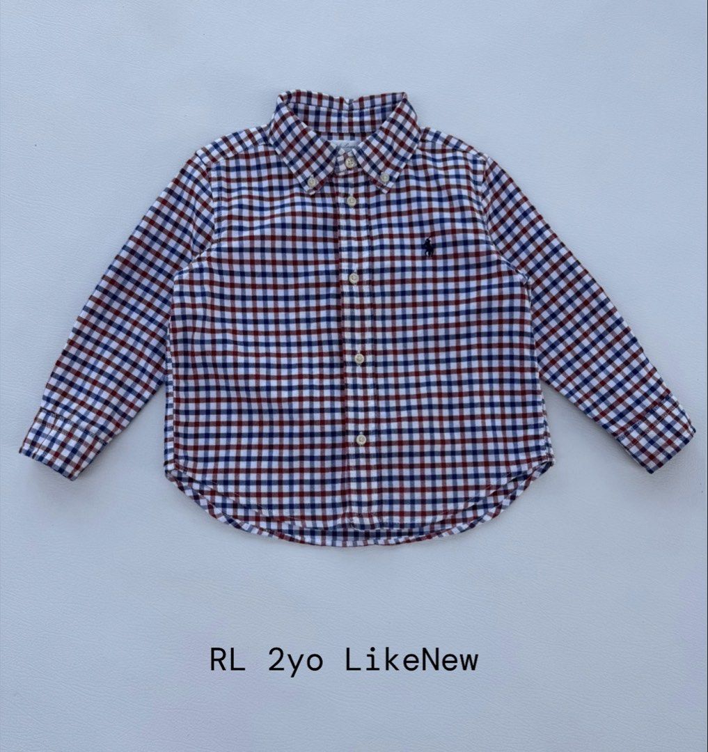 Ralph Lauren Checked Long Sleeve Button-Down Shirt (Category: Babies & Kids Fashion) located in Pozorrubio. Submitted by izaykite2g (Listing ID 1470682532, Image 1). Description: - Color/Pattern: Red, white, and blue check - Size: Fits toddlers around 2 years old - Features: Long sleeves with button cuffs, classic collar, front button closure, and curved hemline - Detail: Small embroidered pony logo on the chest - Condition: Clean fabric with bri