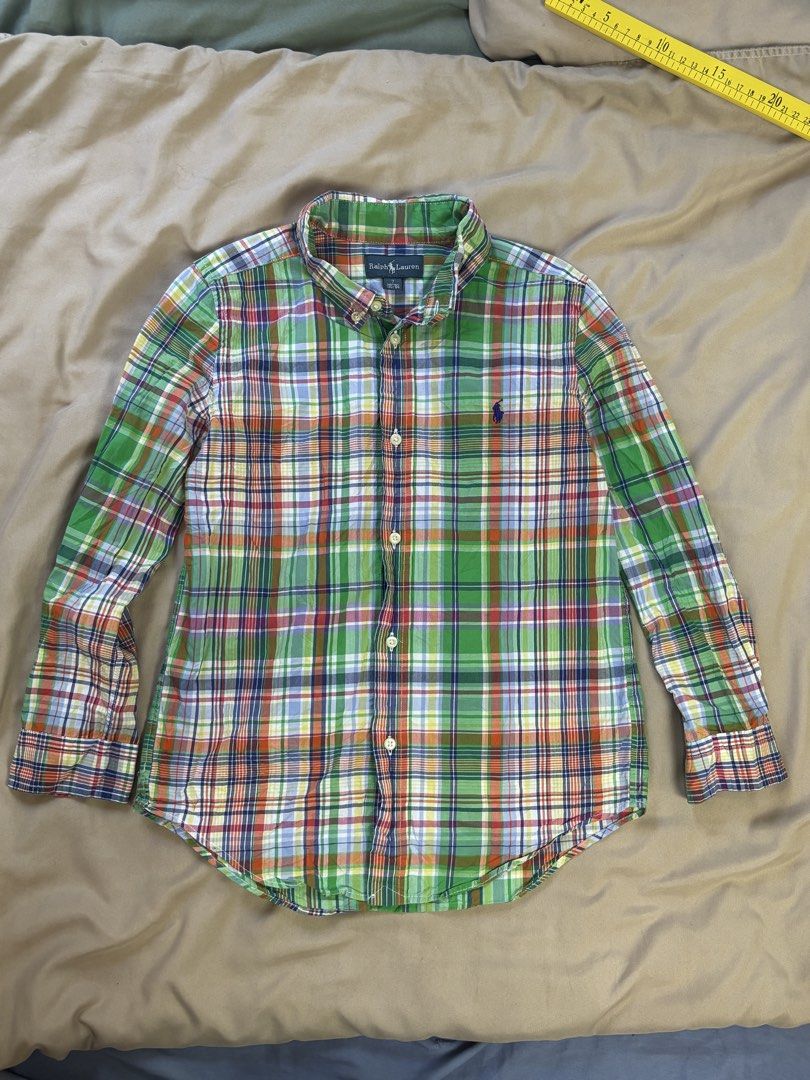Ralph Lauren Plaid Button-Down Shirt Size 7 (Category: Babies & Kids Fashion) located in Ajuy. Submitted by galitsabarat (Listing ID 1470615137, Image 1). Description: - Brand: Ralph Lauren - Item: Boys button-down shirt - Design: Green plaid with blue, orange, and white accents - Size: 7 (130/64) - Details: Classic collar, long sleeves, front button closure, signature embroidered pony logo - Condition: Clean, excellent, and ready to wear.