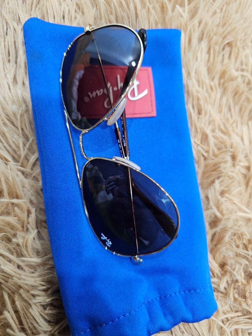 Ray-Ban Aviator Junior Sunglasses (Category: Sunglasses & Eyewear) located in Bulacan. Submitted by ms.gemini (Listing ID 1470689108, Image 2). Description: - Authentic Ray-Ban aviator sunglasses in classic pilot style - Gold metal frames with stylish brown gradient lenses - Laser-etched RB logo on the lens corner for authenticity - Temple arms feature comfortable clear acetate tips - Includes a bright blue Ray-Ban drawstring pouch with the iconi