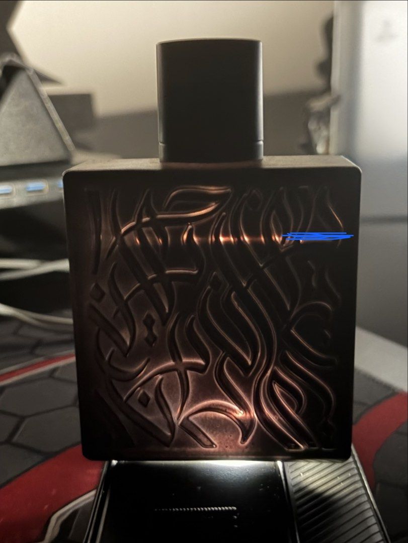 Rayhaan Lion Eau de Parfum (Category: Fragrance & Deodorants) located in Manila. Submitted by akii.0815 (Listing ID 1470603378, Image 2). Description: - Authentic Rayhaan Lion fragrance bottle - Striking black rectangular glass design - Detailed metallic gold and bronze lion emblem on the front - Elegant raised Arabic calligraphy texture on the back - Topped with a sleek black cylindrical cap - Bottle is full with visible liquid level -Comes with