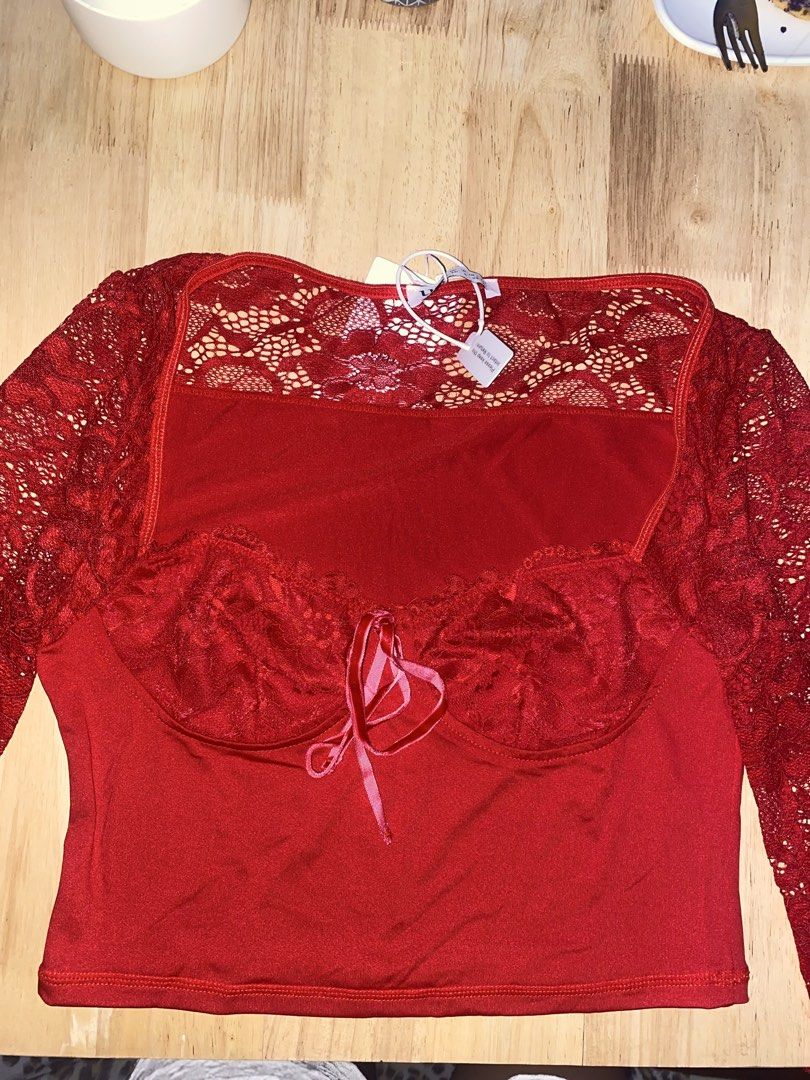 Red lace crop top (Category: Blouses) located in Cavite. Submitted by helloize (Listing ID 1470640717, Image 1). Description: - Brand: Urbanic - Condition: Brand new with original retail tags attached - Size: XS (EU 34 / UK 6 / US 2) - Color: Vibrant red with contrasting light pink ribbon tie - Design: Delicate lace sleeves and upper panel with fitted silhouette - Features: Built-in molded cups for extra support and shape Best fit Small Good qual