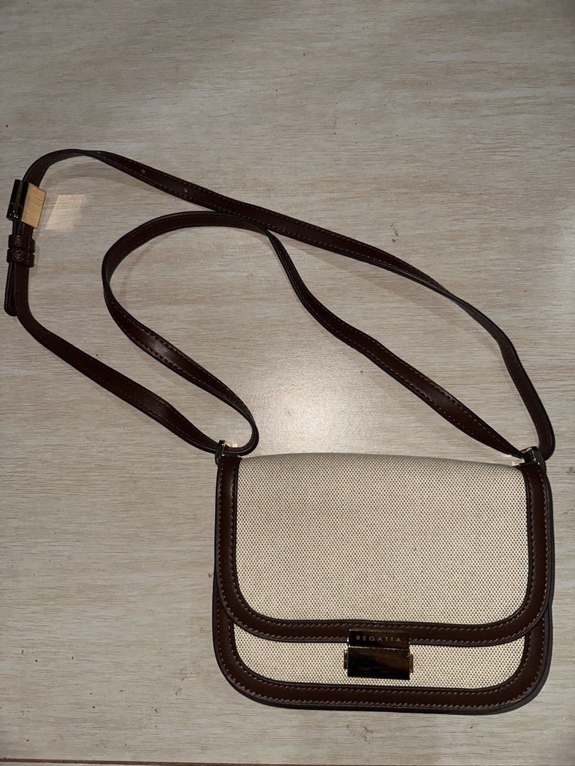 Regatta Crossbody Bag Beige Brown (Category: Cross-body Bags) located in Manila. Submitted by zayzay08 (Listing ID 1470727863, Image 2). Description: - Brand: Regatta - Color: Neutral beige canvas with brown leather-look trim - Closure: Flap with secure gold-tone metal lock hardware - Strap: Adjustable brown strap for a custom fit - Interior: Fabric-lined with a convenient zippered pocket - Style: Versatile and chic, perfect for pairing with ever