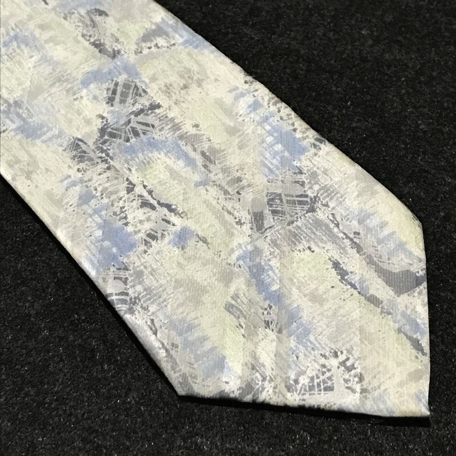 Remizio NWT Abstract Pattern Neck Tie (Category: Ties) located in Taguig. Submitted by retrogaze (Listing ID 1470595647, Image 2). Description: This 100% silk necktie by Remizio features an off-white cream base with a subtle satin luster, decorated with an artistic abstract watercolor print. The design incorporates broad diagonal shadow bands overlaid with painterly brushstrokes, cross-hatching, and textured splashes in muted sky blue, sage green