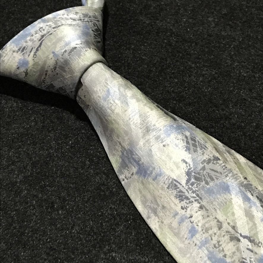 Remizio NWT Abstract Pattern Neck Tie (Category: Ties) located in Taguig. Submitted by retrogaze (Listing ID 1470595647, Image 1). Description: This 100% silk necktie by Remizio features an off-white cream base with a subtle satin luster, decorated with an artistic abstract watercolor print. The design incorporates broad diagonal shadow bands overlaid with painterly brushstrokes, cross-hatching, and textured splashes in muted sky blue, sage green