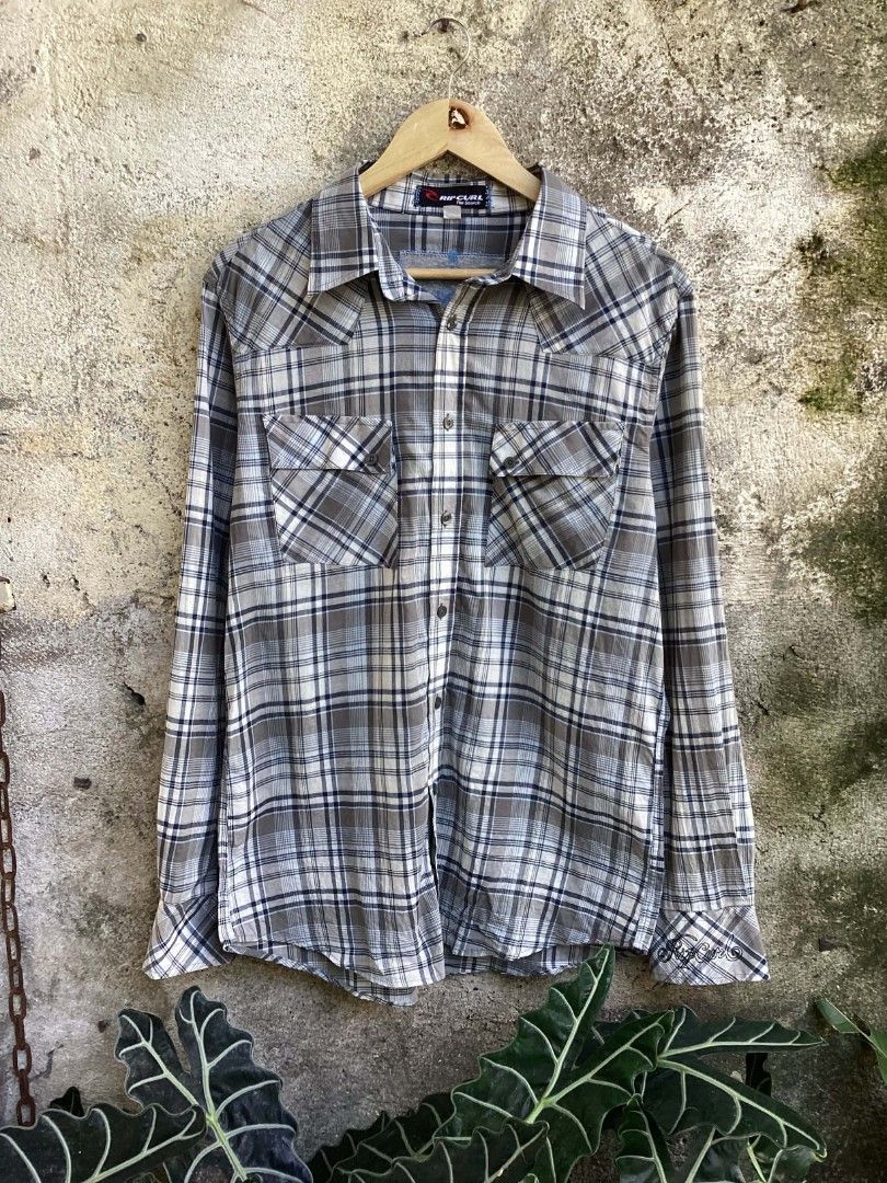 Rip Curl Plaid Button-Up Long Sleeve Shirt (Category: Tshirts & Polo Shirts ) located in Mangaldan. Submitted by manuelingalla_3rd (Listing ID 1470579593, Image 1). Description: - Brand: Rip Curl - Style: Long sleeve button-up shirt with Western front and back yokes - Pattern: Grey, white, and blue plaid - Features: Two chest pockets, standard collar, and front button closure - Branding: Embroidered Rip Curl script logo on the left cuff and patch