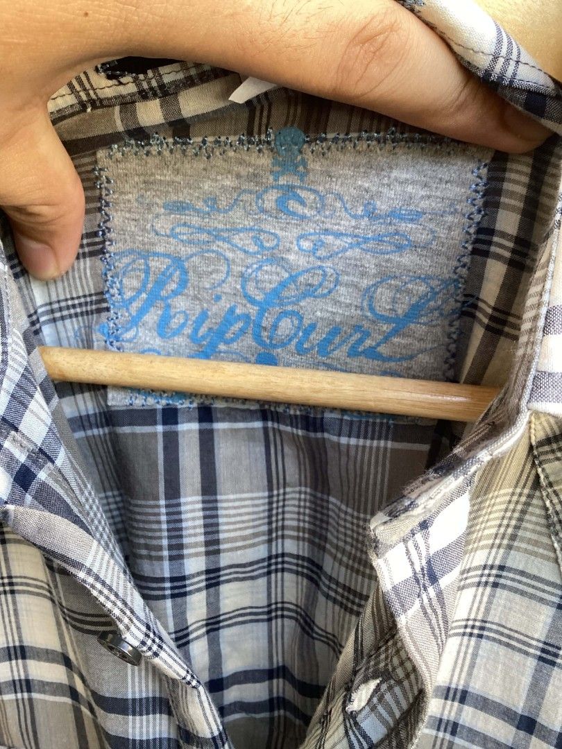 Rip Curl Plaid Button-Up Long Sleeve Shirt (Category: Tshirts & Polo Shirts ) located in Mangaldan. Submitted by manuelingalla_3rd (Listing ID 1470579593, Image 3). Description: - Brand: Rip Curl - Style: Long sleeve button-up shirt with Western front and back yokes - Pattern: Grey, white, and blue plaid - Features: Two chest pockets, standard collar, and front button closure - Branding: Embroidered Rip Curl script logo on the left cuff and patch