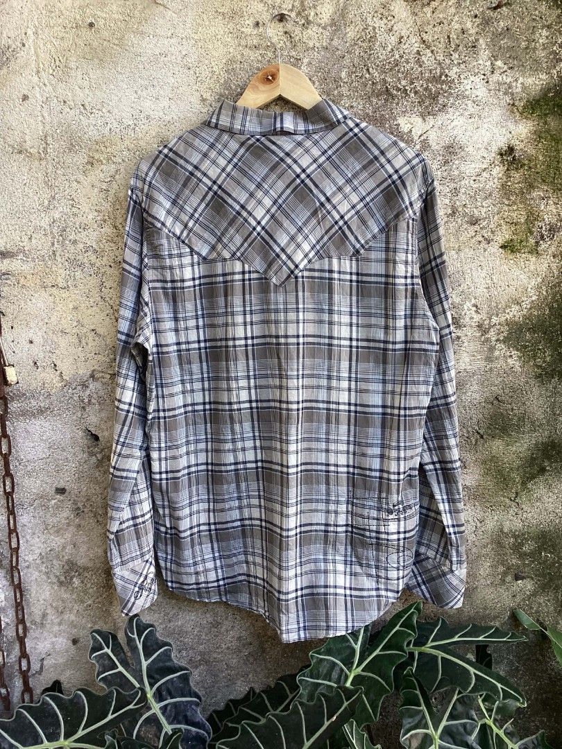Rip Curl Plaid Button-Up Long Sleeve Shirt (Category: Tshirts & Polo Shirts ) located in Mangaldan. Submitted by manuelingalla_3rd (Listing ID 1470579593, Image 2). Description: - Brand: Rip Curl - Style: Long sleeve button-up shirt with Western front and back yokes - Pattern: Grey, white, and blue plaid - Features: Two chest pockets, standard collar, and front button closure - Branding: Embroidered Rip Curl script logo on the left cuff and patch