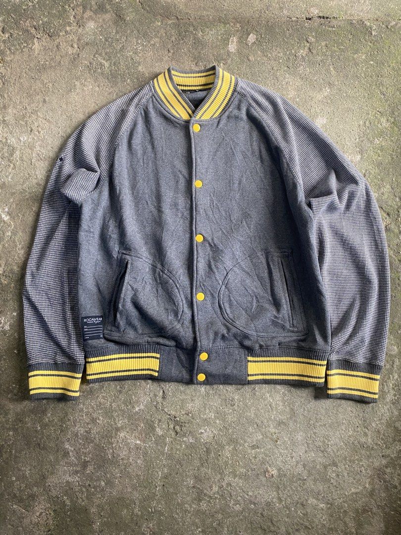 Rocawear Varsity Jacket Grey Houndstooth Sleeves Yellow Ribbing (Category: Coats, Jackets and Outerwear) located in Caloocan City. Submitted by remythrift (Listing ID 1470589868, Image 1). Description: - Brand: Rocawear - Style: Varsity jacket / Streetwear layer - Color: Dark grey with houndstooth patterned sleeves - Details: Yellow and grey striped ribbing (collar, cuffs, hem), front snap button closure, dual side pockets, signature Rocawear tag
