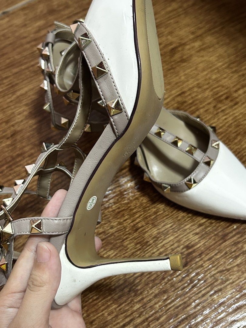 Rockstud Pointed Toe T-Strap Heels White Grey (Category: Heels) located in Manila. Submitted by harmsluv (Listing ID 1470643280, Image 2). Description: FOR SALE: Pointed-Toe Studded Strappy Heels 👠✨ DETAILS - Color: White and nude/taupe with gold studs - Style: Pointed-toe, strappy heels - Size: 38-39 - Heel Height: 2.5-3 inches heels - Condition: BRAND NEW/ NEVER BEEN USED 💰 Price: ₱299 negotiable 📍 Location: Fairview, QC 🚚 Delivery: Meetup 