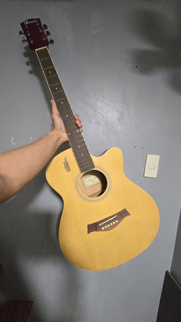 Rosen R-125 Acoustic Guitar (Category: Musical Instruments) located in Caloocan City. Submitted by marces (Listing ID 1470669520, Image 1). Description: - Brand/Model: Rosen R-125 acoustic guitar - Design: Natural wood finish with standard cutaway - Smooth cosmetic overall but has some issues below: Issues: -Bridge is lifting off the soundboard and needs repair, -Slight rusting in the tuners - cosmetic damage at the bottom back edge - no strings 